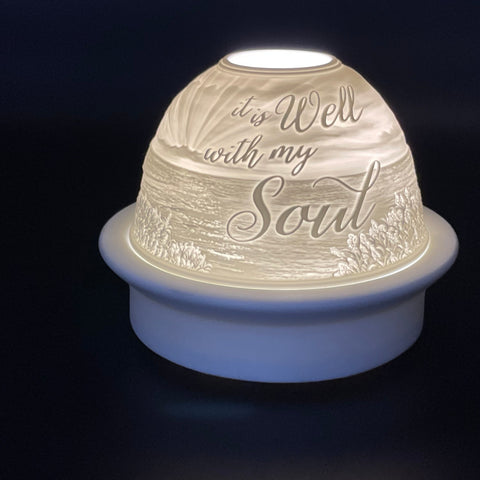 Decorative light with 'it is well with my soul' engraving on a dark background