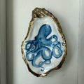Decorative oyster shell with blue octopus design on a white background