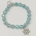Bracelet with light blue beads and a silver snowflake charm on a white background